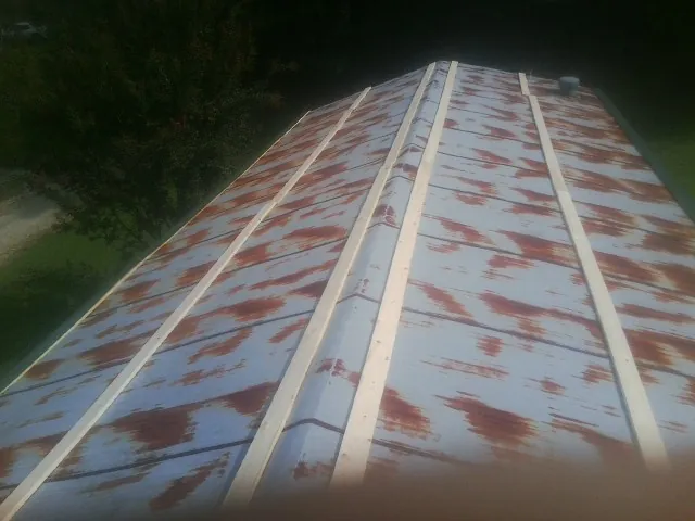 Rusted metal roof panels with new wood purlins before replacement — Storm Damage Roof Repair in Campobello by Roofing Brothers
