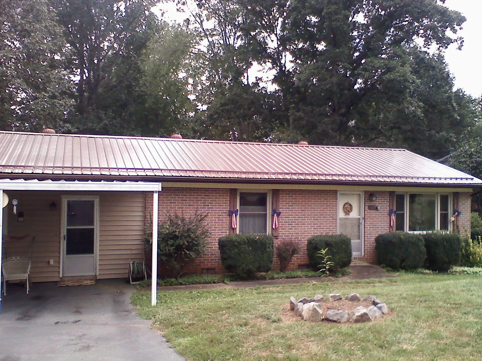 Bronze metal roof and carport on a brick ranch home — Roof Repair work by our crew in Campobello